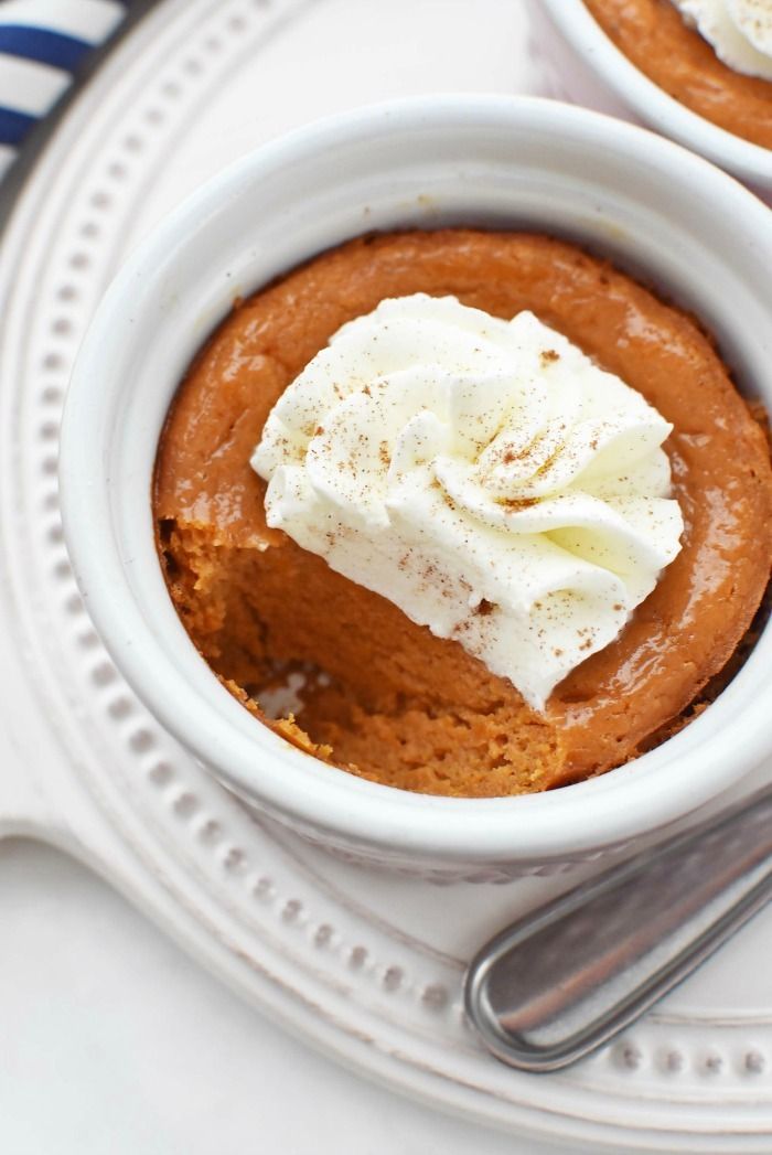 two small white bowls filled with dessert on top of a plate next to a fork