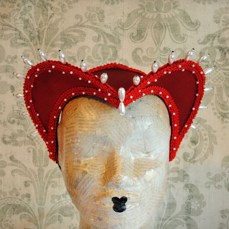 This striking red heart shaped attifet headdress is a great piece to top off your Queen of Hearts costume or any other costume in the red color palette. It is covered with candy apple red silk shantung and embellished with red trimming all around the edges.This unique piece wouldn't be complete without all those wonderful pearl bead details that add some royal flair to it's elegance. The headpiece is very light and comfortably stays in place with an adjustable elastic that goes under the hair and at the back of the neck. You can adjust the strap to be as tight as you want. Also available in other color combinations in the shop or just send me a message to talk about a custom piece that will match your costume! This item is sent packaged securely and sent out with DHL Express, delivered in Fairytale Costume, Gothic Headdress, Top Hat Costume, Fairy Tale Costumes, White Gothic, Queen Of Hearts Costume, Bridal Headdress, Red Colour Palette, Vampire Costume