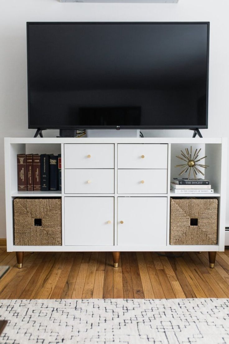 a flat screen tv sitting on top of a white cabinet