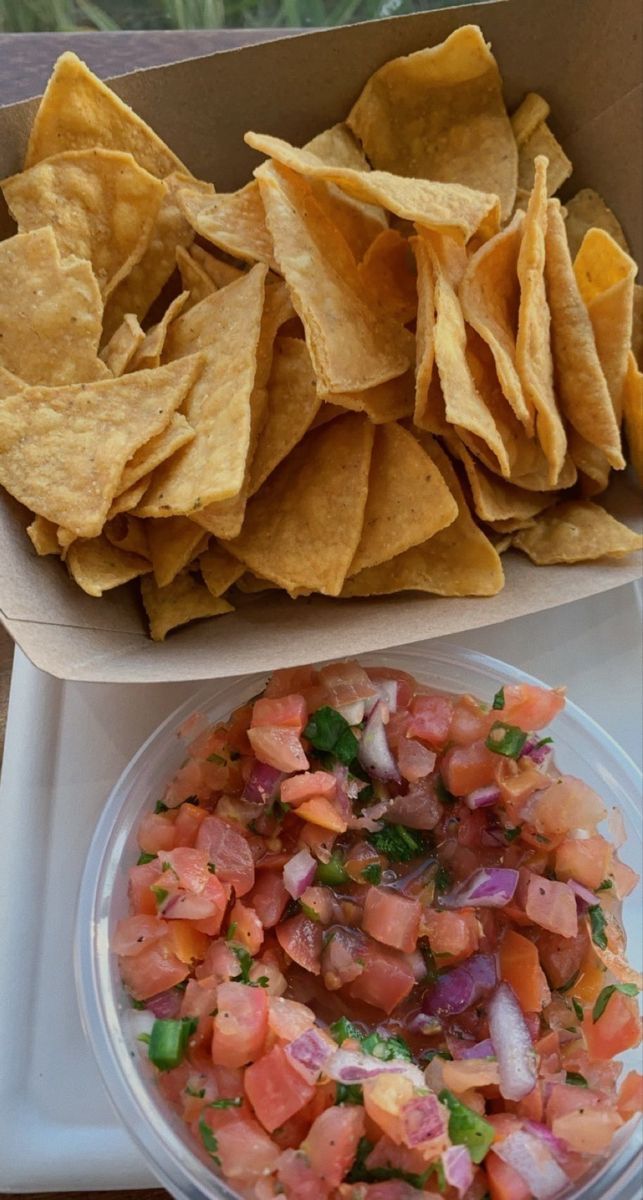 a tray with chips and salsa on it