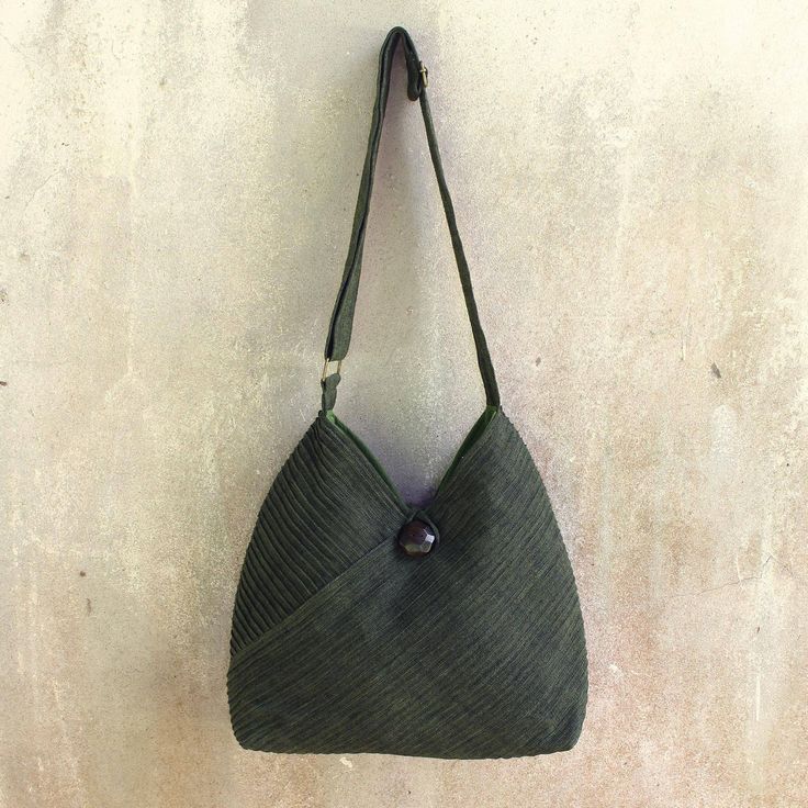 Vinita's flair for style and Thai elegance is evident in the modern design of this leaf green hobo bag. A removable coin purse adds to its versatile allure. Two exterior pockets are camouflaged among the diagonal pintucks that shape the cotton shoulder bag. The fully-lined interior includes two open pockets as well as a zipper pocket. The shoulder strap's length is adjustable and an ornate rain tree wood button closes the bag. Green Hobo Bag With Adjustable Strap For On-the-go, Olive Bags With Detachable Strap For Daily Use, Modern Olive Shoulder Bag, Green Rectangular Hobo Bag With Detachable Handle, Green Hobo Bag With Detachable Handle, Khaki Hobo Shoulder Bag With Removable Pouch, Green Hobo Bag With Detachable Strap For Travel, Olive Crossbody Bag With Removable Pouch, Green Crossbody Hobo Bag For Daily Use