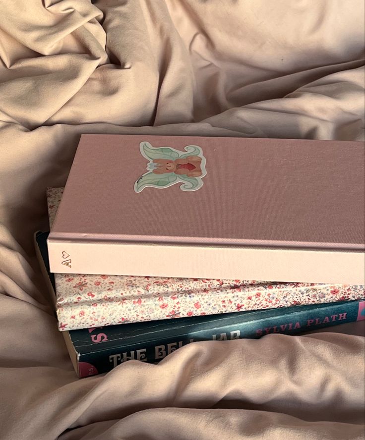 a stack of books sitting on top of a bed