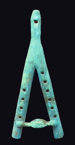 an ancient bronze letter with holes in the middle