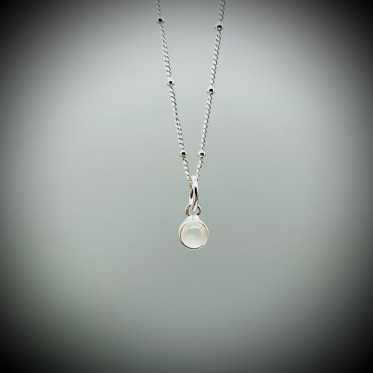 Dainty Moonstone Crystal and sterling silver pendant on a sterling silver satellite chain.  A beautifully polished Moonstone crystal encased in sterling silver (approx. 6mm) on a sterling silver satellite chain. All of our jewellery comes beautifully gift boxed and bagged along with a description of your crystal's benefits. Our jewellery also makes an amazing gift. We are happy to ship this direct for you with a personal message on one of our handprinted cards.  Just let us know you message at c Silver Moonstone Crystal Pendant Necklace, Silver Crystal Necklaces With Birthstone, Moonstone, Moonstone Crystal Necklace, Minimalist Nickel-free Sterling Silver Crystal Necklaces, Nickel-free White Moonstone Necklace, Moonstone Benefits, Sliver Necklace, Nickel-free Moonstone Pendant Jewelry, Moonstone Pendant Necklace