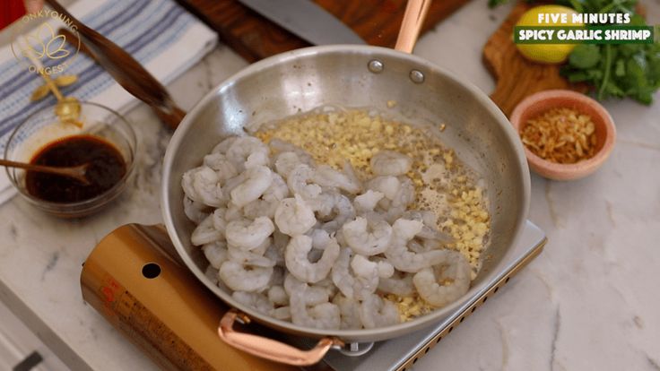 shrimp being cooked in a pan on top of a stove