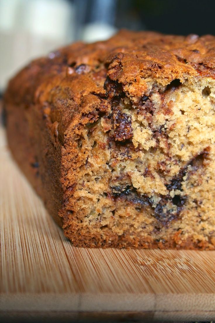 a loaf of banana bread sitting on top of a wooden cutting board