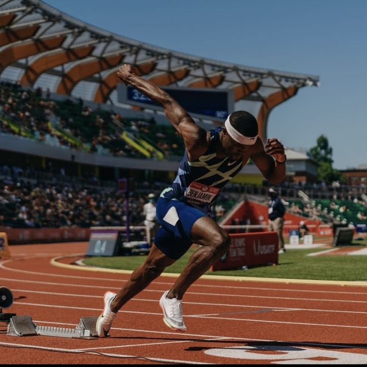 a man running on a track in front of an audience