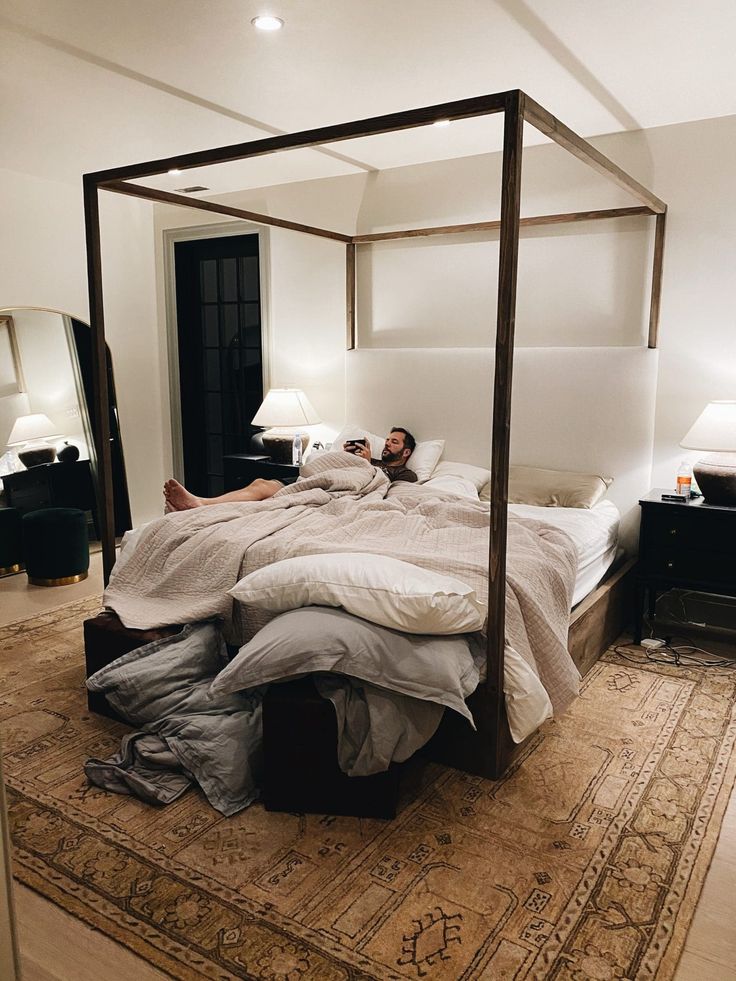 a man laying on top of a bed in a bedroom