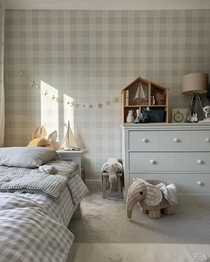 a bed room with a neatly made bed next to a night stand and chest of drawers