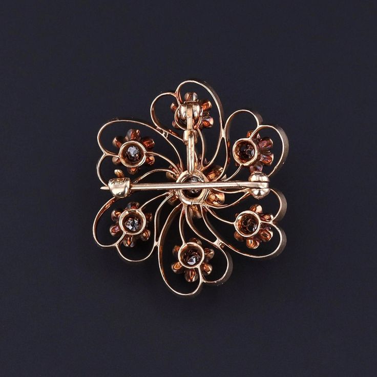 This antique brooch (circa 1890) features 7 old European cut diamonds set in 14k gold. The center diamond is a 0.12ct stone and the total carat weight of all the diamonds is approximately 0.57ct. The piece has a collapsible bail so that the it can be worn either as a brooch or a pendant. The diamond brooch measures 1.25 inches from the top of the bail (when extended) to bottom by 1 inch wide, and it is in great condition. Materials: 14k gold, Diamond. Antique Gold Brooches With Rose Cut Diamonds, Victorian Diamond Filigree Brooches, Antique Gold Diamond Brooches, Victorian Gold Diamond Brooches, Vintage Gold Brooches With Rose Cut Diamonds, Vintage Single Cut Diamonds Brooches For Gift, Vintage Brooches With Single Cut Diamonds As Gift, Heirloom Yellow Gold Brooches With Rose Cut Diamonds, Vintage Brooches With Single Cut Diamonds For Gifts