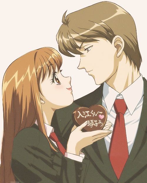 a man and woman kissing while holding a heart shaped donut in front of them