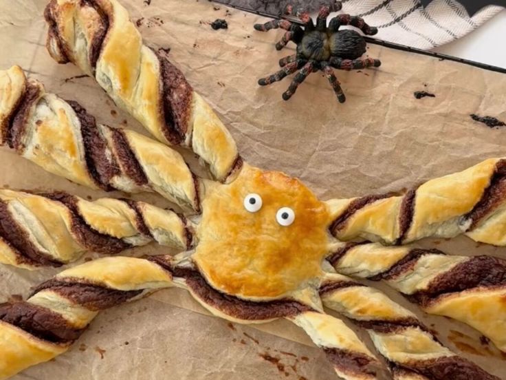 an octopus made out of bread sitting on top of a piece of paper with googly eyes