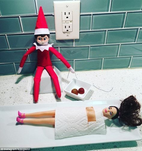 an elf is laying on the counter next to two dolls