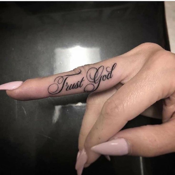 two hands with tattoos that say trust god and one has a finger tattoo on it