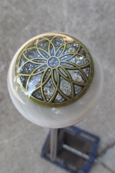 a close up of a door knob on a metal pole with diamonds in the center