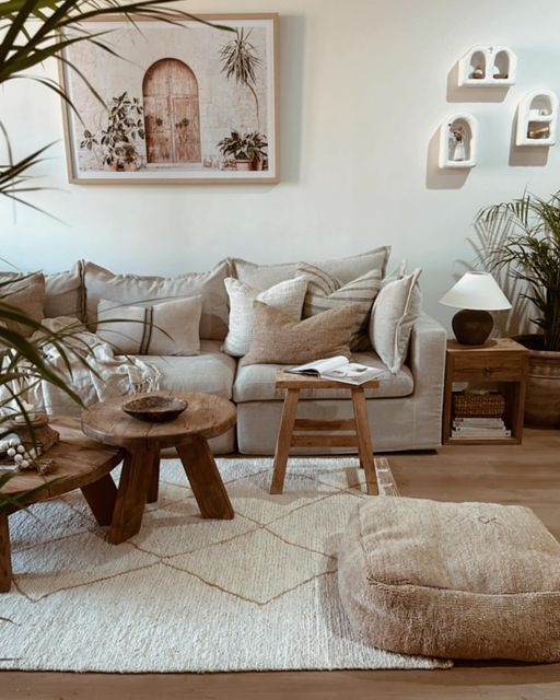 a living room filled with lots of furniture and plants on top of the rugs