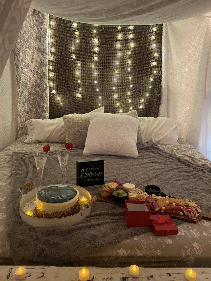 a bed that has some food on it and candles in the room around it with lights