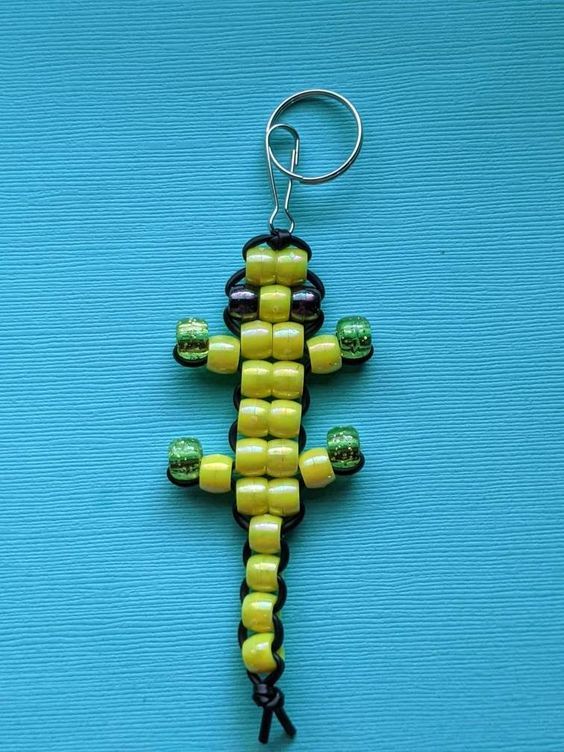 a yellow and black beaded cross on a blue background