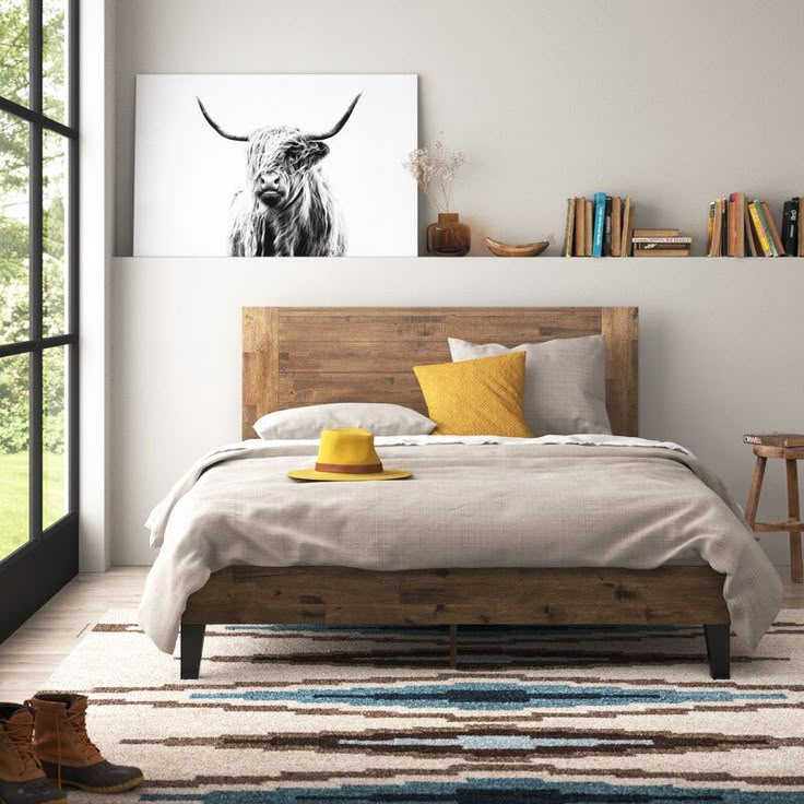 a bed room with a neatly made bed and a cow painting on the wall above it