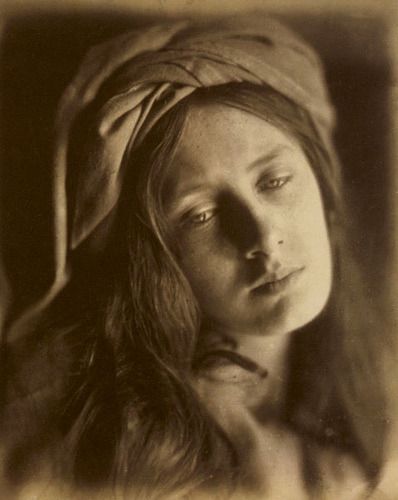 an old black and white photo of a woman with a head scarf on her head