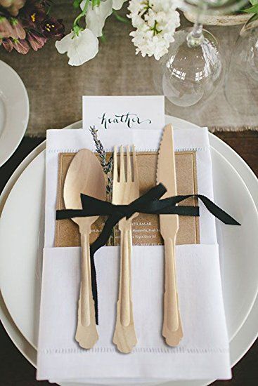 the place setting is set with gold and black forks, napkins, and silverware