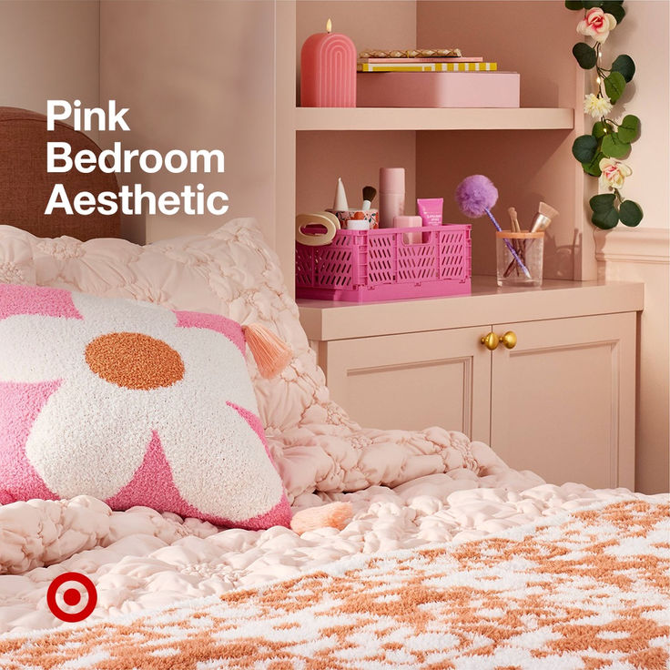 a bed with pink and white pillows on top of it next to a book shelf