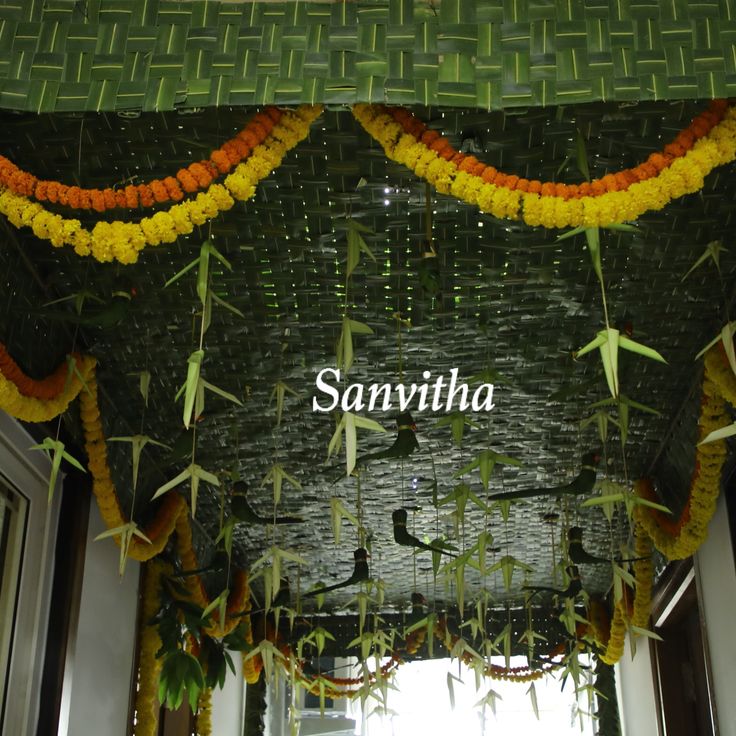 an entrance to a building decorated with flowers and bamboo rafters that spell out sanviha