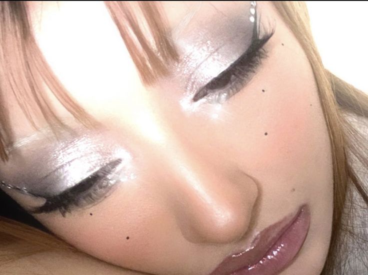 a close up of a woman's face with eyeliners and makeup on