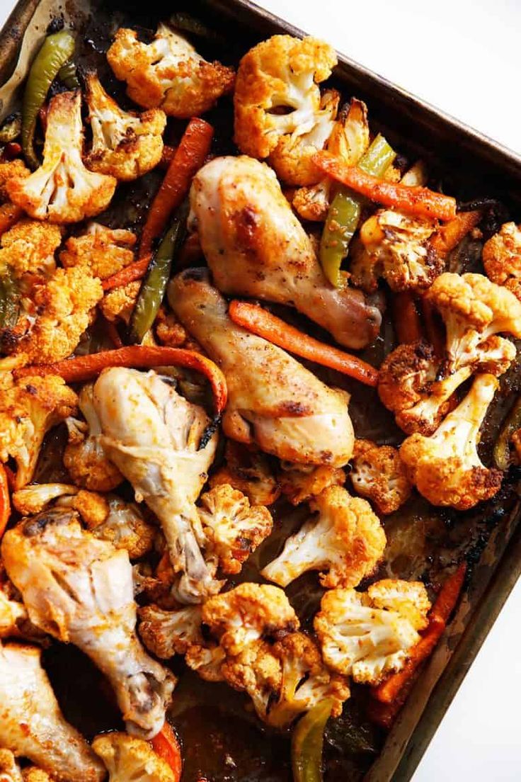 chicken and vegetables are being cooked in a pan