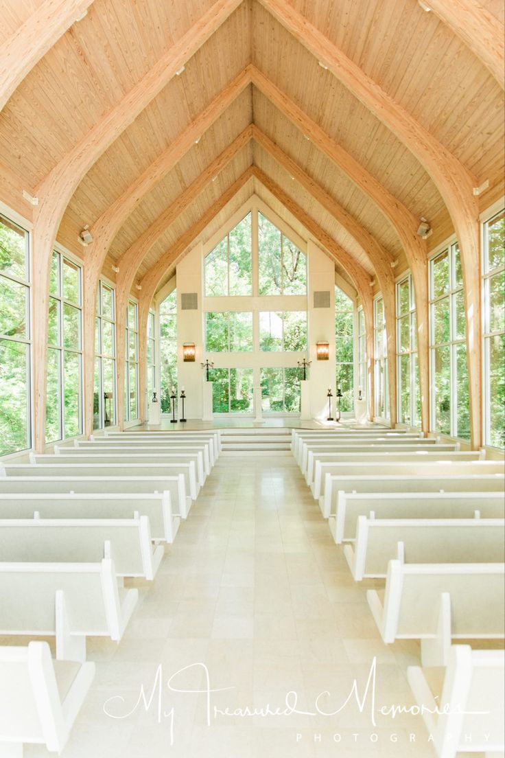 the inside of a church with rows of pews in front of large windows and doors