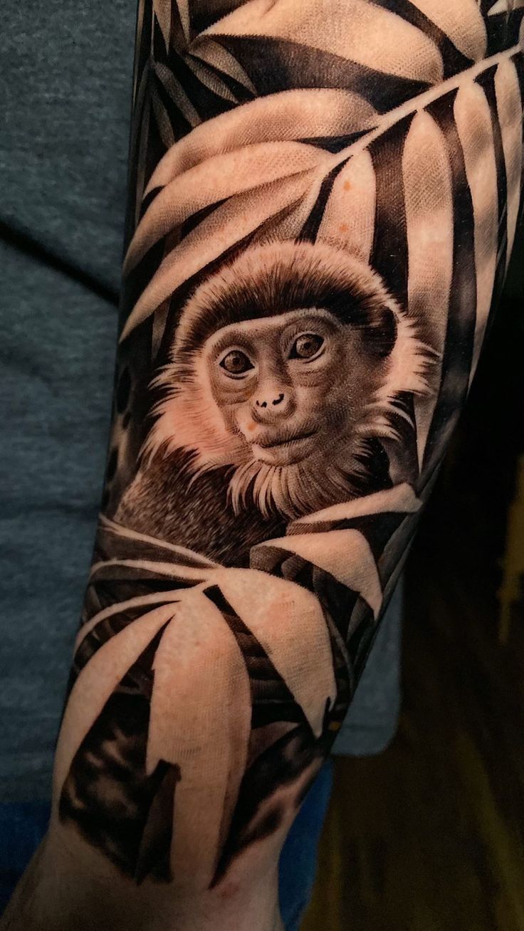 a man's arm with a monkey on it and some black and white stripes