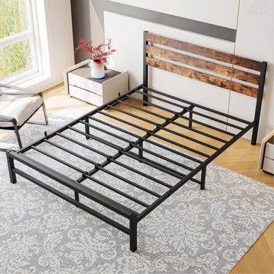 the bed frame is made from metal and has wooden slats on it, along with a white rug