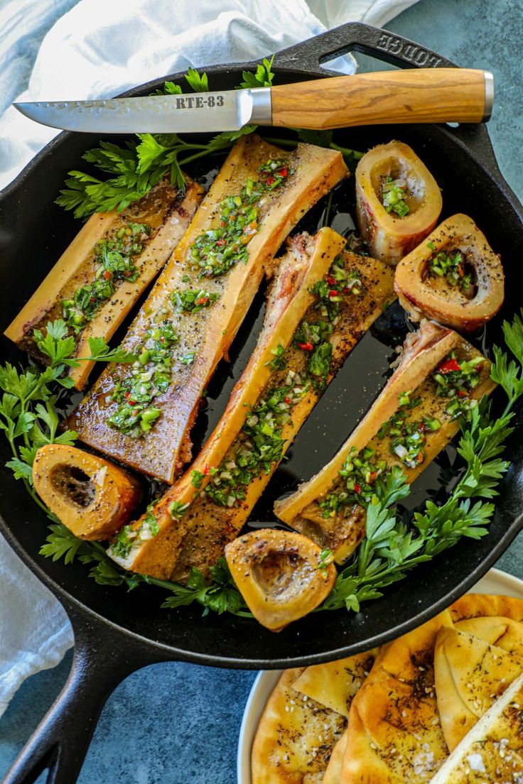 fish and bread in a skillet with parsley on the side for garnish