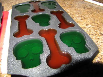 a muffin pan filled with green and red frosting molds on a counter