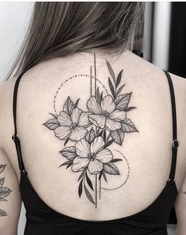 the back of a woman's shoulder with flowers on her left side and an arrow in