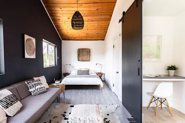 a living room filled with furniture and a wooden ceiling