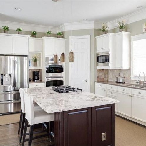 a kitchen with white cabinets and an island in the middle of the room is shown