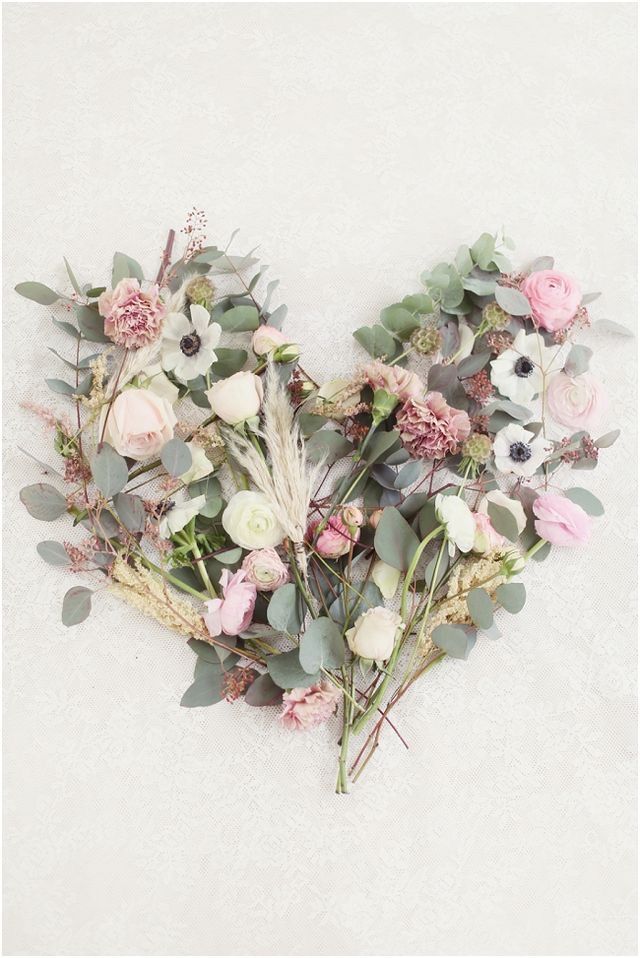 an arrangement of flowers arranged in the shape of a heart