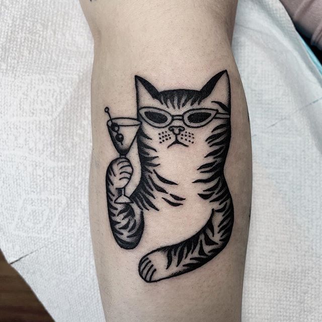 a black and white cat tattoo on the arm