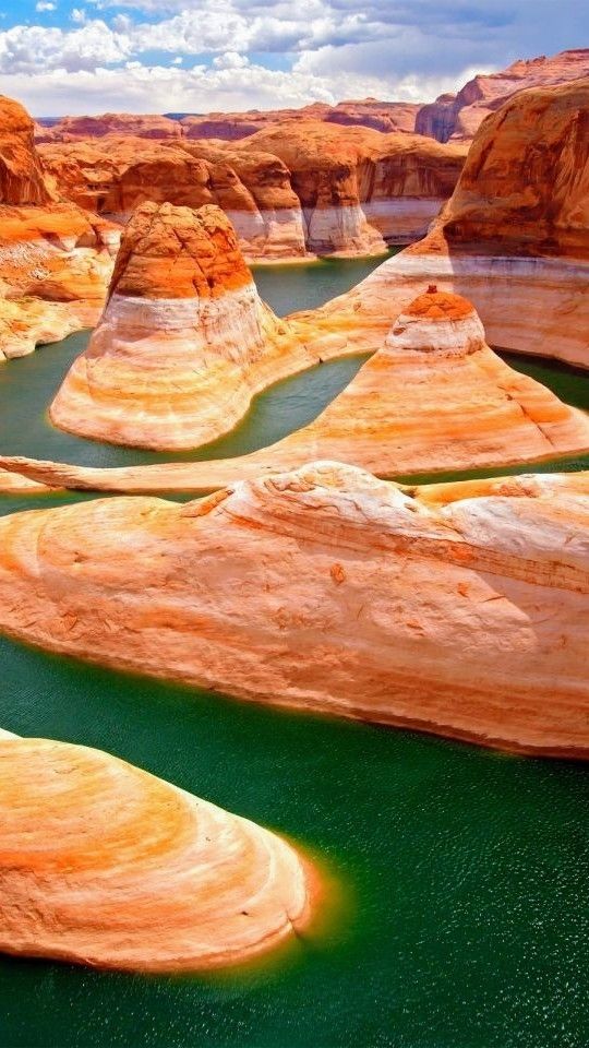 the water is green and brown in this desert area with large rocks on both sides