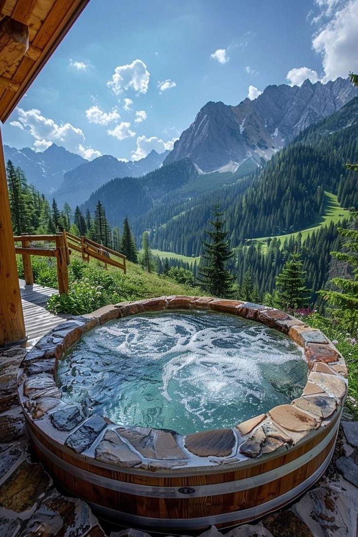 an outdoor hot tub with mountains in the background