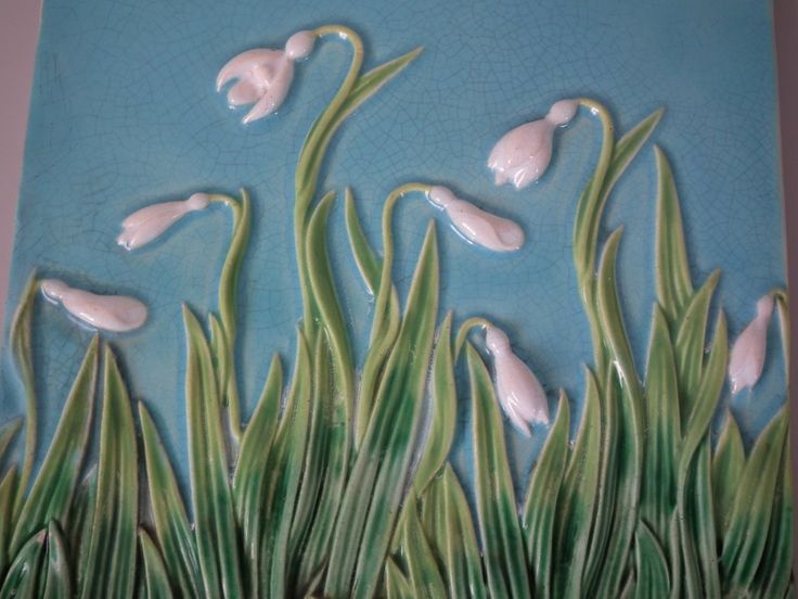 a painting of flowers and grass on a blue background