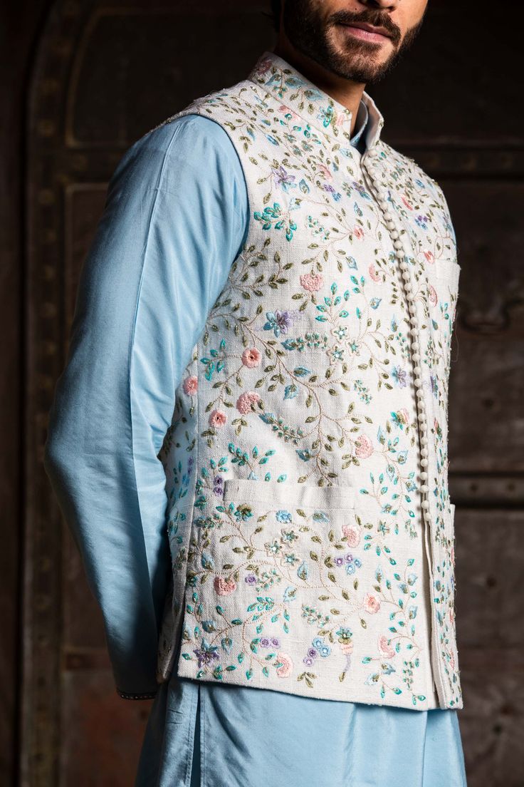 Editor's Note Ivory Matka Bundi Jacket Embroidered In Delicate Floral Pattern Highlighted With Dabka And Beads With Powder Blue Viscose Silk Kurta And Cream Dhoti Color: Ivory, Blue Fabric: Bundi: Matka Silk, Kurta: Viscose Silk, Dhoti: Modal Satin Component: Bundi, Kurta And Pants Embroidery Details: Dabka And Beads Care: Dry Clean Only About the Designer Nitika Gujral’s journey with designing clothes started almost four decades back while she was still in high school and held her first exhibit Potli Button, Pants Embroidery, Kurta And Pants, Blue Kurta, Silk Kurta, Sequin Embroidery, Nehru Jackets, Pattern Embroidery, Satin Color