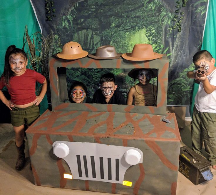 three children standing in front of a fake tv set