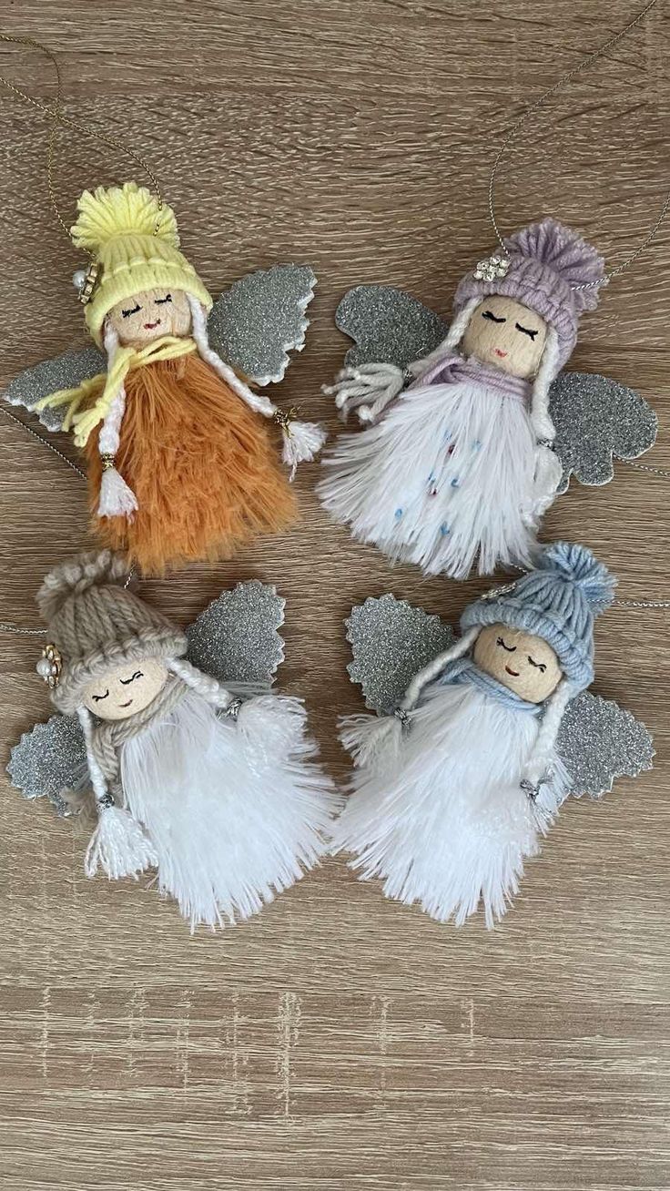 four little angel ornaments sitting on top of a wooden table