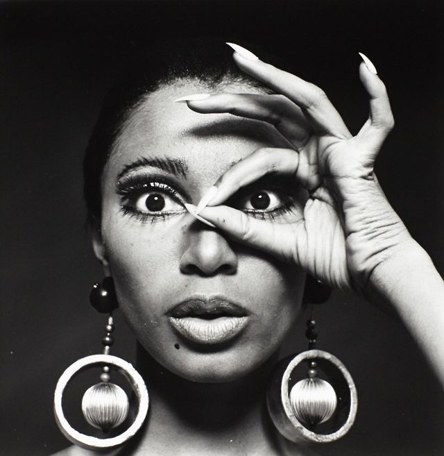 a black and white photo of a woman holding her hands up to her face