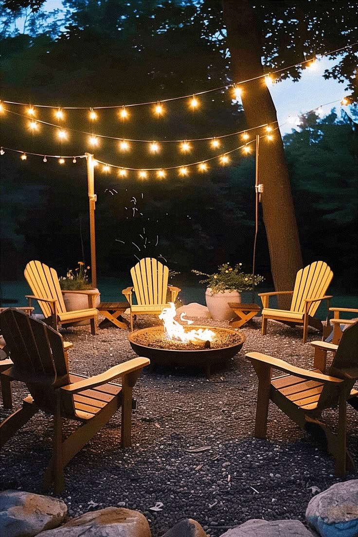 an outdoor fire pit surrounded by chairs and lights