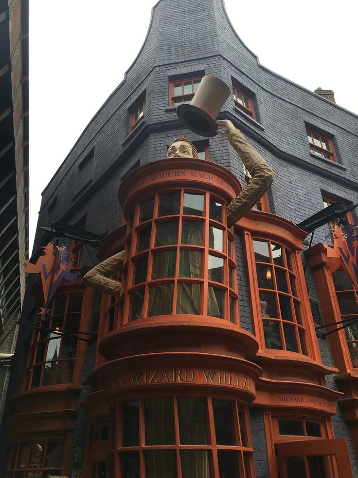 a tall building with a man on top of it's roof and an upside down window