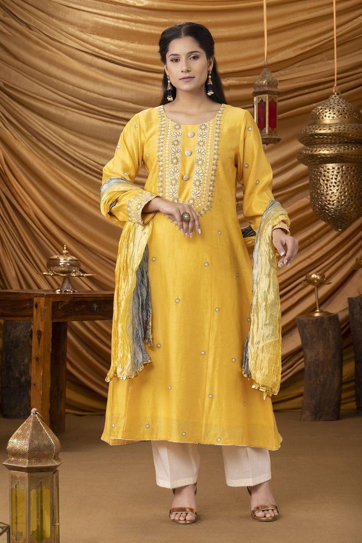 Mango yellow A-line kurta with hand embroidered chikankari and handmade pearl buttons. Paired with crinkled ombre shaded cotton silk dupatta and pant. 
Component: 3
Pattern: Embroidered
Type Of Work: Chikankari
Neckline: Round
Sleeve Type: Long Sleeves
Fabric: Kurta-Chanderi, Dupatta-Crinkled cotton silk 
Color: Yellow
Other Details: 
Chikankari work
Shaded dupatta
Pearl buttons
Occasion: Haldi - Aza Fashions Designer Chanderi Kurta With Dabka Work, Gold Slub Silk Palazzo Set With Dabka Work, Traditional Yellow Semi-stitched Salwar Kameez, Gold Palazzo Set With Dabka Work In Slub Silk, Traditional Chanderi Palazzo Set With Gota Work, Traditional Drape Chanderi Palazzo Set With Gota Work, Chanderi Palazzo Set With Gota Work, Diwali Traditional Cotton Silk Wear With Gota Work, Diwali Traditional Wear With Gota Work In Cotton Silk