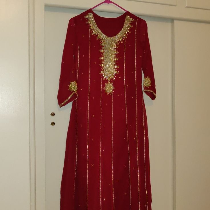 Beautiful Gorgeous Red/Maroon Gold Outfit. Comes With The Maxi Kameez (Shirt), Plazoo Pants (Has Elastic Waist Band) And Dupatta (Shawl). Never Worn Before. All Sales Are Final, No Returns Accepted. Measurements As Follows Which Shows In Inches. Shirt: Shoulder - 14 Bust - 17 Sleeves- 20 Length - 49 1/2 Pants: Length - 37 1/2 Red Sharara With Dabka For Navratri, Red Dabka Sharara For Navratri, Red Mirror Work Salwar Kameez For Eid, Red Salwar Kameez With Mirror Work For Eid, Red Anarkali Palazzo Set With Dabka Detailing, Red Palazzo Set For Navratri Celebration, Red Long Sleeve Palazzo Set With Dabka Details, Red Anarkali Palazzo Set With Dabka, Red Palazzo Set For Navratri Party